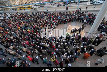 Dresden, Deutschland. Februar 2024. Im Rahmen der Gedenktage versammeln sich die Menschen, um gemeinsam vor dem Kulturpalast zu singen. Den ganzen Tag über finden in der Stadt Gedenkveranstaltungen zum 79. Jahrestag des Bombenanschlags auf Dresden statt. Quelle: Matthias Rietschel/dpa-Zentralbild/dpa/Alamy Live News Stockfoto