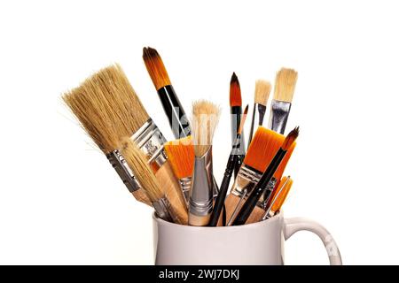Pinsel verschiedener Arten und Farben in vertikaler Position auf weißem Hintergrund. Stockfoto