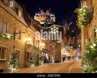 Die Skyline von Quebec City wird im Winter bei Dämmerung beleuchtet. Die Rue Sous-le-Fort ist weihnachtlich dekoriert Stockfoto