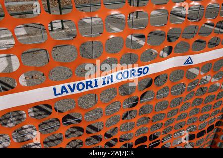 Gut sichtbares Netz, Arbeiten auf einer Baustelle, Zaun einer Baustelle mit gut sichtbaren orangefarbenen Elementen. Sicherheit Stockfoto