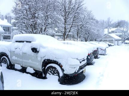 Schneebedeckte Autos auf dem Parkplatz eines Apartmentkomplexes Stockfoto