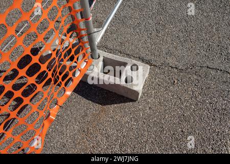 Gut sichtbares Netz, Arbeiten auf einer Baustelle, Zaun einer Baustelle mit gut sichtbaren orangefarbenen Elementen. Sicherheit Stockfoto