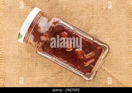 Erdbeermarmelade in einem Glas auf einer Jute-Serviette, Makro, Draufsicht. Stockfoto