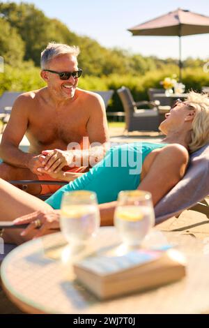 Seniorenpaar Im Urlaub In Badekleidung, Entspannend Am Hotelpool Stockfoto