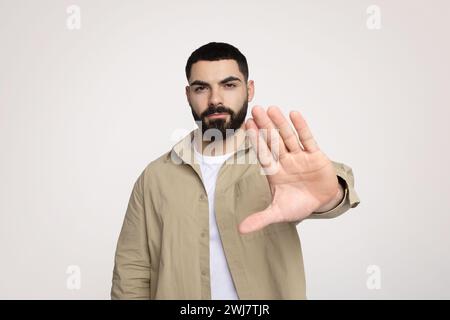 Trauriger zuversichtlicher junger lateinmann mit Bart in lässiger Form machen Hand-Stop-Geste Stockfoto