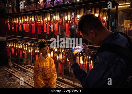 Hongkong, Hongkong. Februar 2024. Ein Junge, verkleidet in Lunar Silvesterkostüm, posiert für ein Foto für seinen Vater im man Mo Temple in Hongkong. Die Menschen strömten zum man Mo Tempel, um am vierten Tag des Mondneujahrs in Hongkong als Tradition zu verehren und das Mondneujahr und das Jahr des Drachen im chinesischen Tierkreiszeichen zu feiern. (Foto: Alex Chan TSZ Yuk/SOPA Images/SIPA USA) Credit: SIPA USA/Alamy Live News Stockfoto