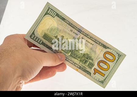 Echtheitsprüfung der Banknote in Höhe von 100 Dollar für die Freigabe. Wasserzeichen auf einem 100-Dollar-Schein. Banknote in der Hand auf weißem Hintergrund mit Wasserzeichen. Frankl Stockfoto