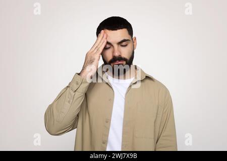 Trauriger junger lateinmann mit Bart in lässiger Hand auf die Stirn gelegt, leidet an Kopfschmerzen Stockfoto