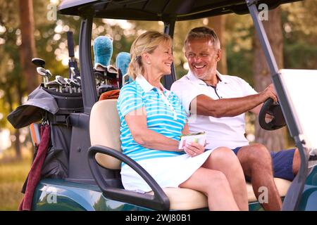 Senior Pärchen Sitzen Im Buggy Auf Dem Golfplatz Und Markieren Gemeinsam Die Punktekarte Stockfoto