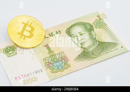 China-Geld-Rechnung Yuan mit Bitcoin. Vergoldeter Bitcoin auf chinesischer Yuan-Note. Renminbi. Chinesisches Yuan-Geld und Kryptowährung Bitcoin-Nahaufnahme. Digi Stockfoto