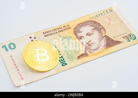 goldene Bitcoin-Münze auf uns argentinien Pesos Nahaufnahme Makro. Elektronische Kryptowährung auf Argentinien Wert für Geld. Bitcoin Kryptowährung und Argentinien PE Stockfoto