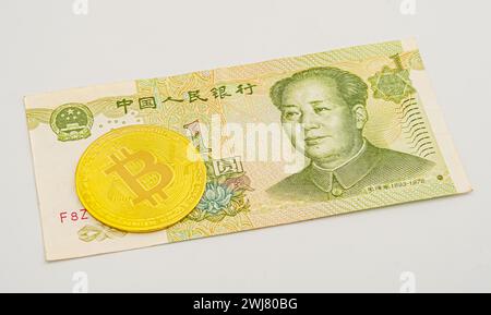 China-Geld-Rechnung Yuan mit Bitcoin. Vergoldeter Bitcoin auf chinesischer Yuan-Note. Renminbi. Chinesisches Yuan-Geld und Kryptowährung Bitcoin-Nahaufnahme. Digi Stockfoto