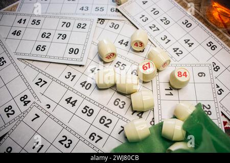 Lottospiel spielen. Würfel mit Figur auf Bingo-Karte Hintergrund. Nostalgie Lifestyle. Tischspiele. Retro-Spiele. Fass mit Nummer und Papierkarten. Stockfoto