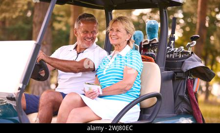 Senior Pärchen Sitzen Im Buggy Auf Dem Golfplatz Und Markieren Gemeinsam Die Punktekarte Stockfoto