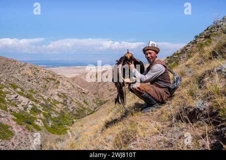 Traditioneller kirgisischer Adlerjäger mit Adler in den Bergen, in der Nähe von Kirgisil-Suu, Kirgisistan Stockfoto