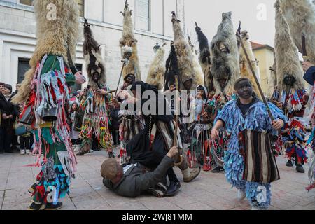 Sinj, Kroatien. Februar 2024. Menschen, die Schafvlies auf dem Kopf tragen, nehmen am 13. Februar 2024 an der Karnevalsparade der Region Cetina in Sinj, Kroatien, Teil. Didi aus Kamesnica tragen auf ihren Köpfen Schafvliese, bis zu 1,5 Meter hoch und Glocken um die Taille. Sie tragen alte Kleider, die mit bunten Fransen genäht sind. Sie symbolisieren den rituellen Kampf der guten Geister gegen den Winter, indem sie ihn verjagen, indem sie Lärm machen und auf und ab springen. Foto: Ivana Ivanovic/PIXSELL Credit: Pixsell/Alamy Live News Stockfoto