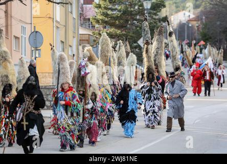 Sinj, Kroatien. Februar 2024. Menschen, die Schafvlies auf dem Kopf tragen, nehmen am 13. Februar 2024 an der Karnevalsparade der Region Cetina in Sinj, Kroatien, Teil. Didi aus Kamesnica tragen auf ihren Köpfen Schafvliese, bis zu 1,5 Meter hoch und Glocken um die Taille. Sie tragen alte Kleider, die mit bunten Fransen genäht sind. Sie symbolisieren den rituellen Kampf der guten Geister gegen den Winter, indem sie ihn verjagen, indem sie Lärm machen und auf und ab springen. Foto: Ivana Ivanovic/PIXSELL Credit: Pixsell/Alamy Live News Stockfoto