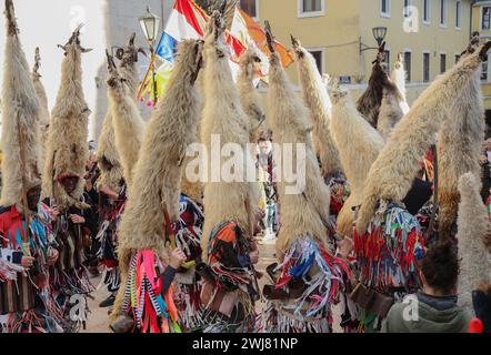 Sinj, Kroatien. Februar 2024. Menschen, die Schafvlies auf dem Kopf tragen, nehmen am 13. Februar 2024 an der Karnevalsparade der Region Cetina in Sinj, Kroatien, Teil. Didi aus Kamesnica tragen auf ihren Köpfen Schafvliese, bis zu 1,5 Meter hoch und Glocken um die Taille. Sie tragen alte Kleider, die mit bunten Fransen genäht sind. Sie symbolisieren den rituellen Kampf der guten Geister gegen den Winter, indem sie ihn verjagen, indem sie Lärm machen und auf und ab springen. Foto: Ivana Ivanovic/PIXSELL Credit: Pixsell/Alamy Live News Stockfoto