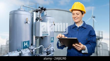 Weibliche Ingenieurin mit Tablet-Computer auf einem Hintergrund der Wasserstofffabrik. Stockfoto