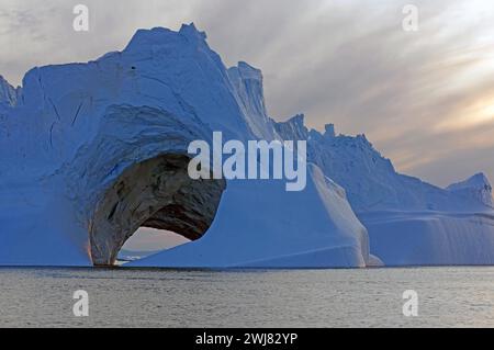 Eisberg mit Höhle, Mitternachtssonne, Ilulissat, Disko Bay, Dänemark, Grönland Stockfoto