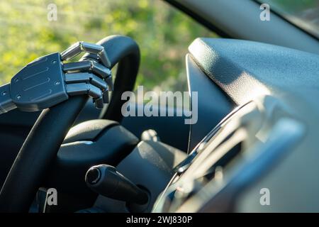 Roboterarm an einem Lenkrad. Künstliche Intelligenz fährt ein Auto. Autonomes Fahrzeugkonzept Stockfoto