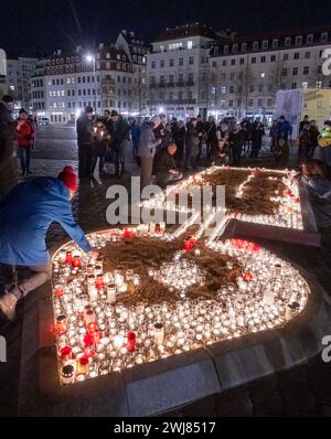 Dresden, Deutschland. Februar 2024. Die Menschen bilden eine große Kerze mit ihren Lichtern auf dem Neumarkt. Den ganzen Tag über finden in der Stadt Gedenkveranstaltungen zum 79. Jahrestag des Bombenanschlags auf Dresden statt. Quelle: Matthias Rietschel/dpa/Alamy Live News Stockfoto