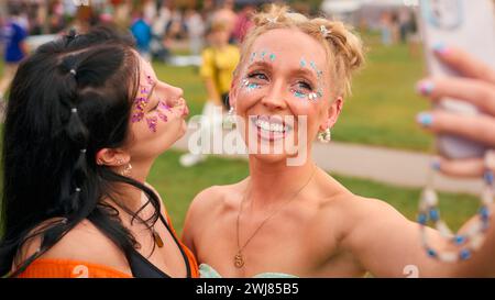 Zwei Weibliche Freunde Tragen Glitzer, Die Für Selfie Beim Summer Music Festival Posierten Stockfoto