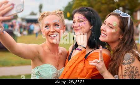 Drei Weibliche Freunde Tragen Glitzer, Die Für Selfie Beim Summer Music Festival Posierten Stockfoto