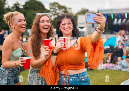 Drei Weibliche Freunde Mit Glitzer Posieren Für Selfie Beim Summer Music Festival Und Halten Drinks Stockfoto