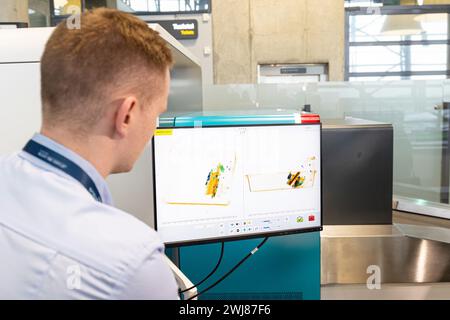 Flughafensicherheit Gepäckkontrolle. Sicherheitsmann, der auf den Monitor schaut, der Gepäck durch einen Röntgenscanner scannt Stockfoto