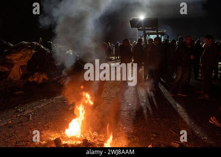 Pontos, Girona, Spanien. Februar 2024. Hunderte katalanischer Bauern blockieren die AP-7 und die N-2 in der Stadt PontÃ³s in der Nähe von Girona und der Grenze zu Frankreich. Während der Blockade haben sie Kiefern abgeholzt und Lagerfeuer gemacht, um die Straße in beide Richtungen zu blockieren. Sie planen, die Nacht zu verbringen. (Kreditbild: © Marc Asensio Clupes/ZUMA Press Wire) NUR REDAKTIONELLE VERWENDUNG! Nicht für kommerzielle ZWECKE! Stockfoto