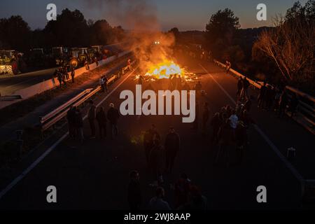 Pontos, Girona, Spanien. Februar 2024. Hunderte katalanischer Bauern blockieren die AP-7 und die N-2 in der Stadt PontÃ³s in der Nähe von Girona und der Grenze zu Frankreich. Während der Blockade haben sie Kiefern abgeholzt und Lagerfeuer gemacht, um die Straße in beide Richtungen zu blockieren. Sie planen, die Nacht zu verbringen. (Kreditbild: © Marc Asensio Clupes/ZUMA Press Wire) NUR REDAKTIONELLE VERWENDUNG! Nicht für kommerzielle ZWECKE! Stockfoto