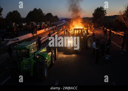 Pontos, Girona, Spanien. Februar 2024. Hunderte katalanischer Bauern blockieren die AP-7 und die N-2 in der Stadt PontÃ³s in der Nähe von Girona und der Grenze zu Frankreich. Während der Blockade haben sie Kiefern abgeholzt und Lagerfeuer gemacht, um die Straße in beide Richtungen zu blockieren. Sie planen, die Nacht zu verbringen. (Kreditbild: © Marc Asensio Clupes/ZUMA Press Wire) NUR REDAKTIONELLE VERWENDUNG! Nicht für kommerzielle ZWECKE! Stockfoto