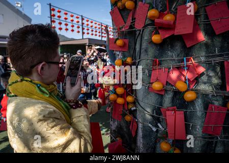 Eine Frau fotografiert eine Drachenpuppe auf dem Wunschbaum beim Hong Kong Well-Well-Wishing Festival. Die Menschen strömten zum Hong Kong Well-Wishing Festival, um am dritten Tag des Lunar New Year in Hongkong ihren Neujahrssegen zu feiern. Dabei wurde das Lunar New Year und das Jahr des Drachen im chinesischen Tierkreiszeichen gefeiert. Stockfoto