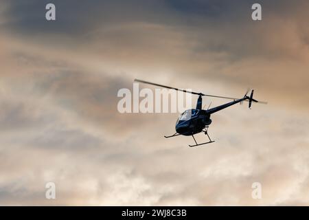 El Campello, Spanien, 13. Februar 2024.Elicopter fliegen am Morgen über den Strand von El Campello mit einem furchterregenden Hintergrund von Wolken Stockfoto