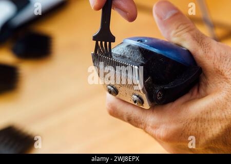 Der Friseur reinigt seinen Haarschneider. Nahansicht. Wartung des Arbeitsgeräts. Stockfoto