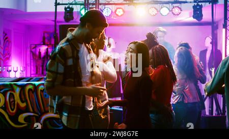 Glückliche Paare feiern im Nachtclub, genießen romantische Musik und tanzen zu zweit. Tanzpartner spazieren und Spaß mit Leuten bei Feierlichkeiten und bei Disco-Partys haben. Handgeführte Aufnahme. Stockfoto