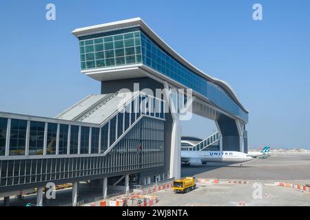 Flugzeuge, die unter dem Chek Lap Kok Airport Sky Deck vorbeifliegen, einer neuen Brücke, die Terminals am Flughafen Hong Kong verbindet. Flugzeug unter dem HKG-Skydeck. Stockfoto