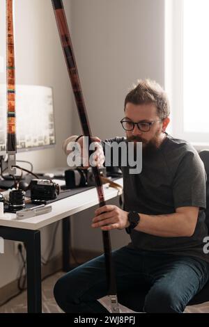 Fotograf untersucht Filmnegative im Studio Stockfoto