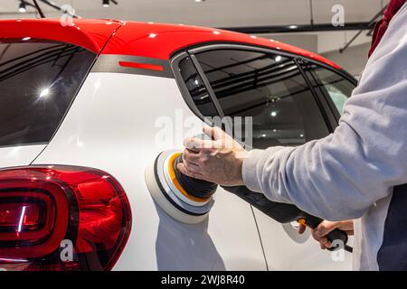 Der Meister poliert das Auto. Meister-Mechaniker-Entfernung von Dellen-Defekten Autoreparaturdienst-Schleiffahne für Kfz-Karosserien. Stockfoto