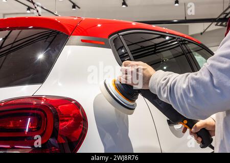 Der Meister poliert das Auto. Meister-Mechaniker-Entfernung von Dellen-Defekten Autoreparaturdienst-Schleiffahne für Kfz-Karosserien. Stockfoto