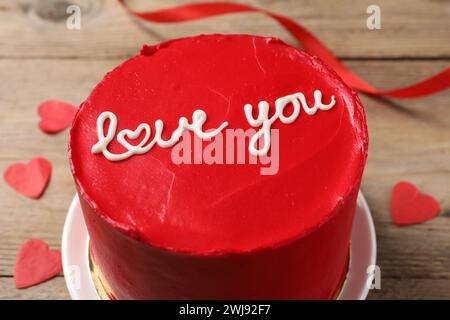 Bento Kuchen mit Text Love You und Papierherzen auf Holztisch, Nahaufnahme. St. Valentinstag-Überraschung Stockfoto