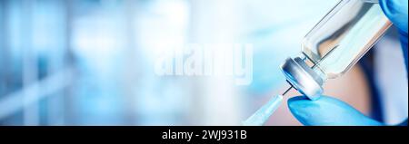 Arzt füllt Spritze mit Medikamenten aus Glasfläschchen auf verschwommenem Hintergrund, Großaufnahme. Bannerdesign Stockfoto