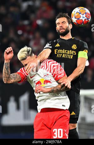 Leipzig, Deutschland. Februar 2024. Nacho (R) von Real Madrid streitet mit Benjamin Sesko aus Leipzig im 1. Leg-Spiel der UEFA Champions League zwischen RB Leipzig und Real Madrid am 13. Februar 2024 in Leipzig. Quelle: Ulrich Hufnagel/Xinhua/Alamy Live News Stockfoto