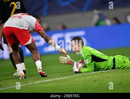 Leipzig, Deutschland. Februar 2024. Andriy Lunin (R), Torhüter von Real Madrid, begrüßt Lois Openda aus Leipzig beim 1. Leg-Spiel der UEFA Champions League zwischen RB Leipzig und Real Madrid am 13. Februar 2024 in Leipzig. Quelle: Ren Pengfei/Xinhua/Alamy Live News Stockfoto