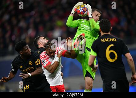 Leipzig, Deutschland. Februar 2024. Andriy Lunin (2. R), Torhüter von Real Madrid, rettet den Ball beim Achtelfinale der UEFA Champions League zwischen RB Leipzig und Real Madrid am 13. Februar 2024 in Leipzig. Quelle: Ren Pengfei/Xinhua/Alamy Live News Stockfoto