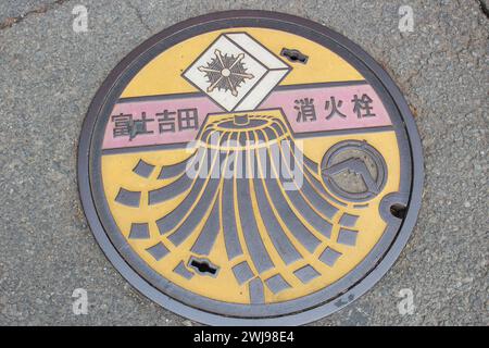 Die wunderschöne und niedliche Abdeckung des Mannlochs hat den Berg Fuji oder Fujisan als Symbol der Stadt Fujiyoshida, Yamanashi, Japan, eingraviert Stockfoto