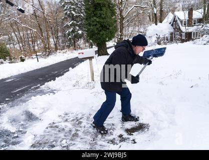 Chappaqua, New York - 13. Februar 2024 - Ein Mann schaufelt seine Auffahrt, nachdem ein Wintersturm über einen Fuß schweren nassen Schnee auf dem Westchester County New Yo abgefeuert hatte Stockfoto