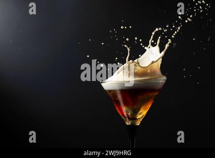 Espresso Martini-Getränk mit Spritzern auf schwarzem Hintergrund. Kopierbereich. Stockfoto