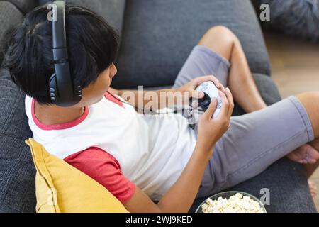 Teenager asiatischer Junge spielt zu Hause gerne mit Kopierraum Stockfoto